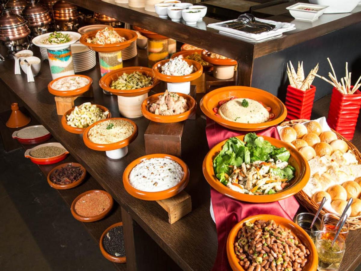 a table with plates of food and bowls of food at Svenska Design Hotel, Electronic City, Bangalore in Bengaluru a table with plates of food and bowls of food at Svenska Design Hotel, Electronic City, Bangalore in Bengaluru