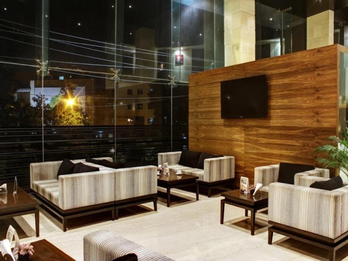 a lobby with couches and tables and a television at Svenska Design Hotel, Electronic City, Bangalore in Bengaluru a lobby with couches and tables and a television at Svenska Design Hotel, Electronic City, Bangalore in Bengaluru