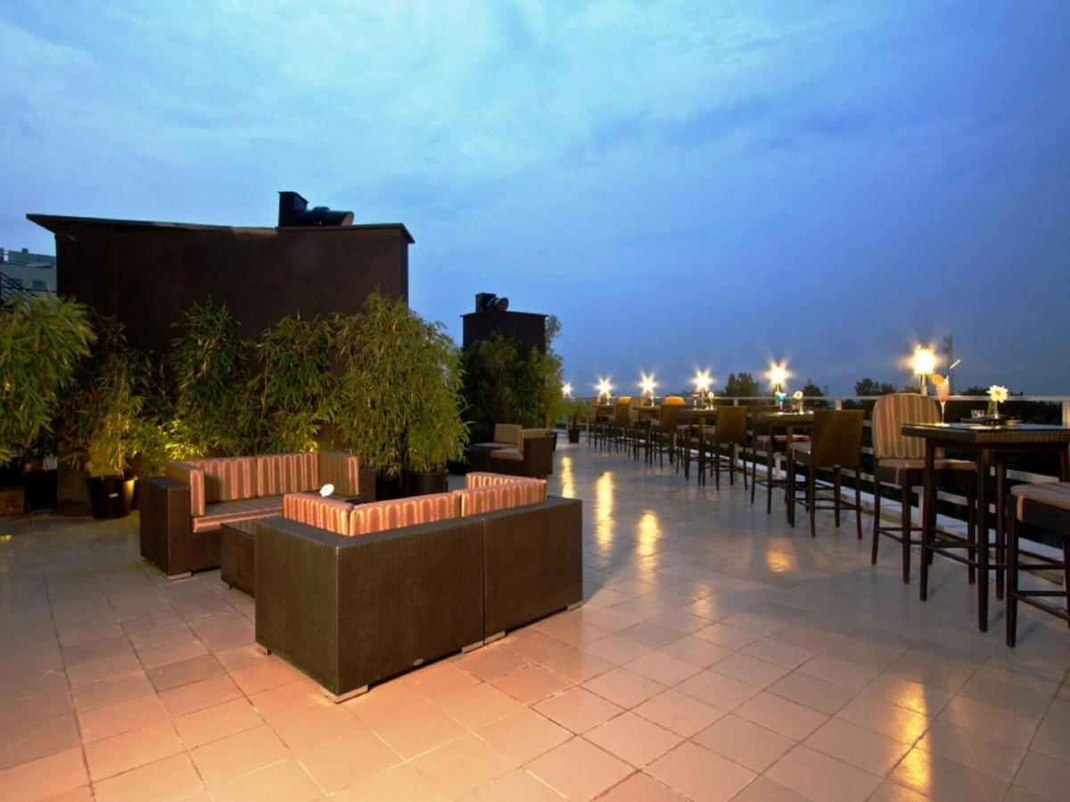 a rooftop patio with tables and chairs at night at Svenska Design Hotel, Electronic City, Bangalore in Bengaluru a rooftop patio with tables and chairs at night at Svenska Design Hotel, Electronic City, Bangalore in Bengaluru