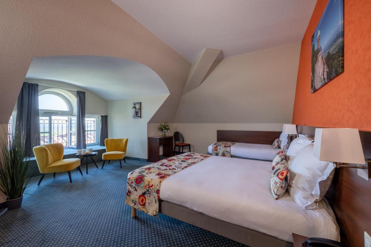 une chambre d'hôtel avec un lit et un bureau dans l'établissement Hôtel Val-Vignes Colmar Haut-Koenigsbourg, The Originals Relais, à Saint-Hippolyte