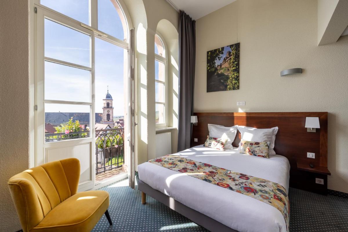 une chambre avec un lit, une chaise et une fenêtre dans l'établissement Hôtel Val-Vignes Colmar Haut-Koenigsbourg, The Originals Relais, à Saint-Hippolyte 63 autres photos