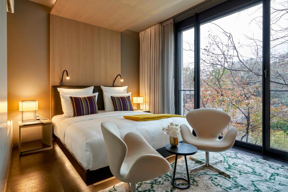 ein Schlafzimmer mit einem Bett und einem großen Fenster in der Unterkunft Das Stue in Berlin