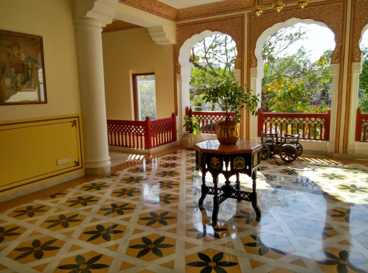an ornate room with a table and a room with windows at Jai Mahal Palace in Jaipur