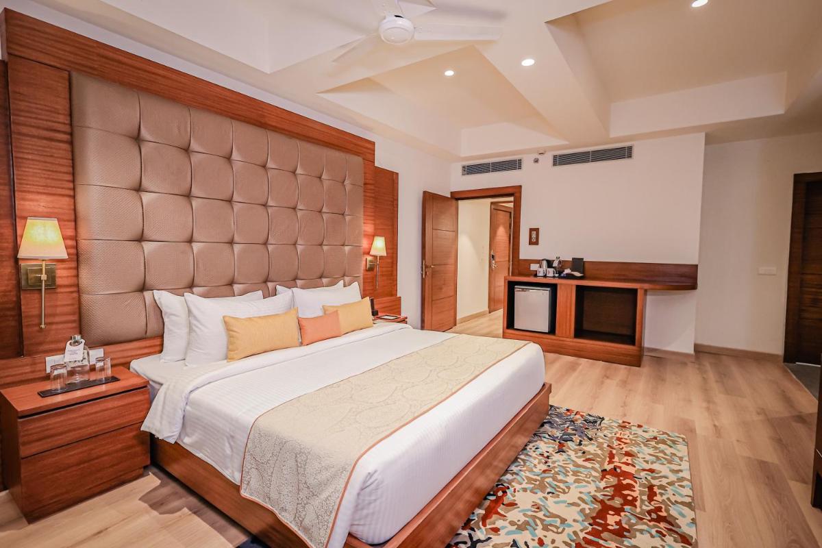 a bedroom with a large bed in a room at Regenta Dehradun by Royal Orchid Hotels Limited in Dehradun