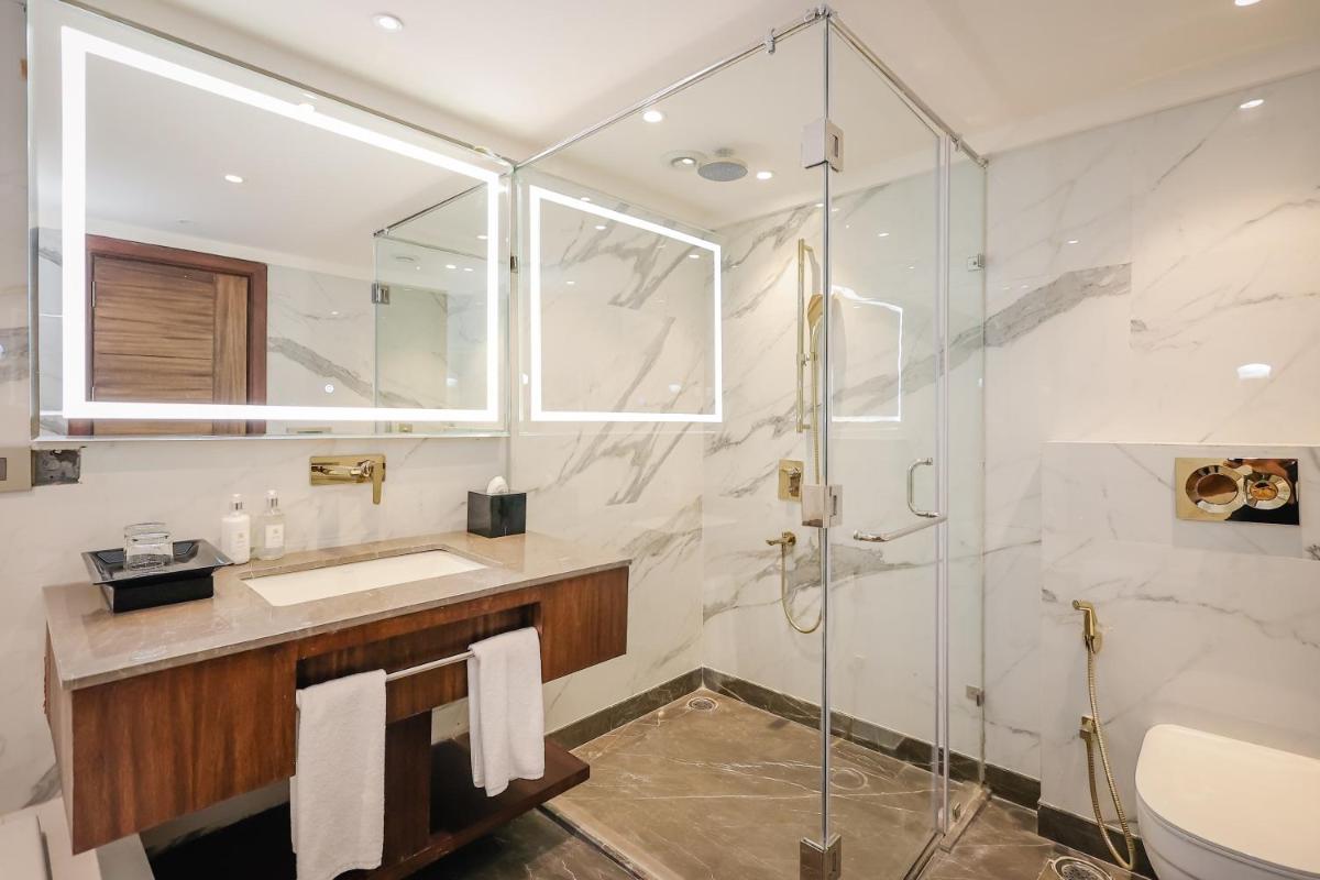 a bathroom with a sink and a shower at Regenta Dehradun by Royal Orchid Hotels Limited in Dehradun
