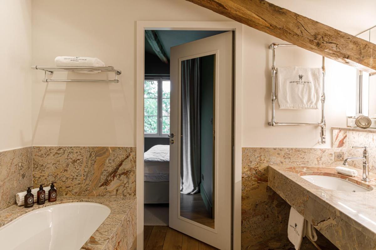 une salle de bains avec deux lavabos et une baignoire dans l'établissement Les Sources de Caudalie, à Martillac