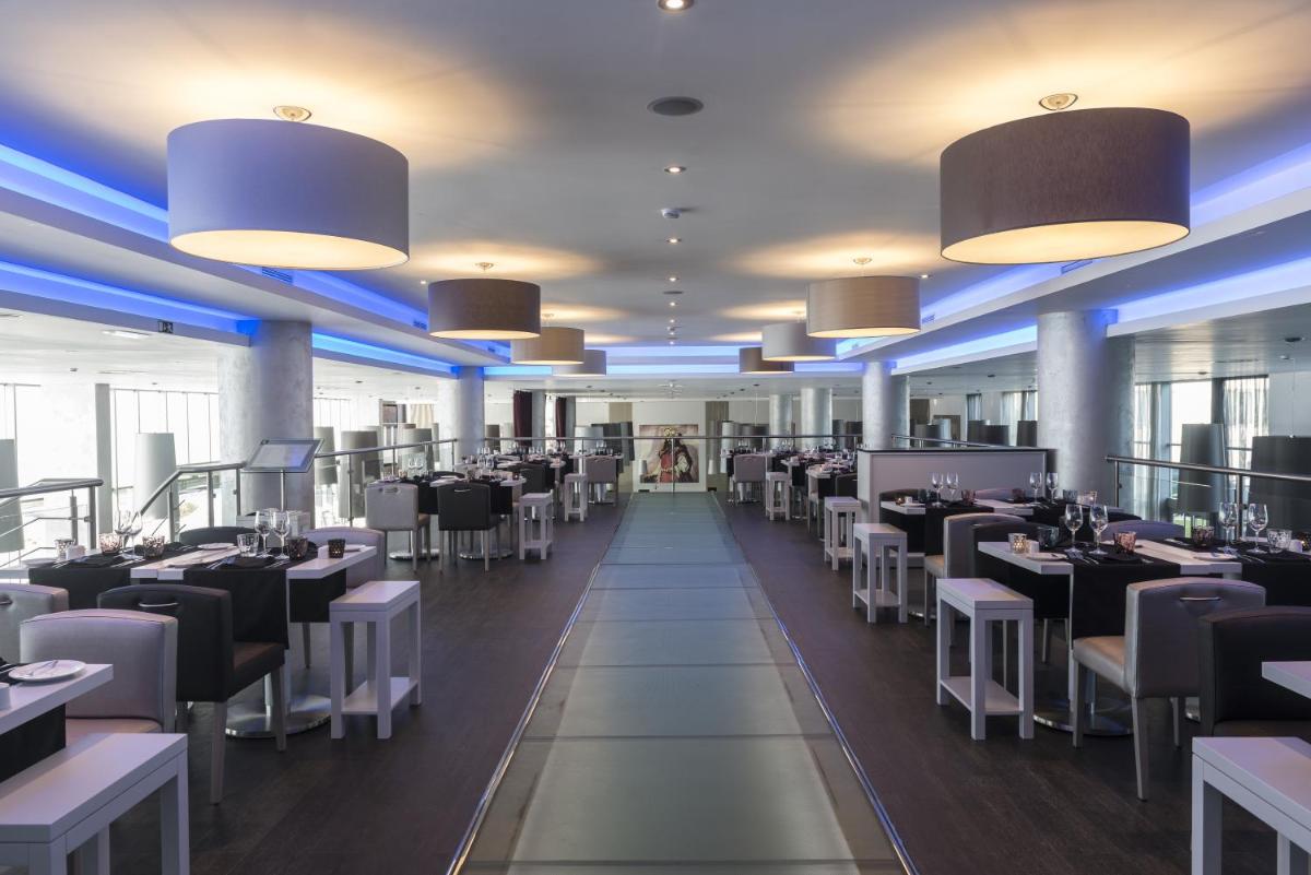 um restaurante com mesas e cadeiras a preto e branco em Vila Gale Evora em Évora