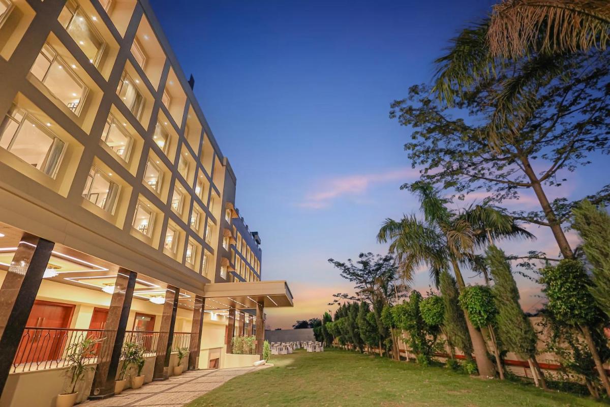 an exterior view of a building with palm trees at Regenta Dehradun by Royal Orchid Hotels Limited in Dehradun