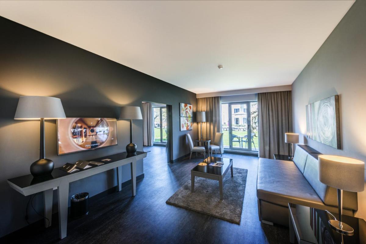 uma sala de estar com um sofá e uma mesa em Vila Gale Evora em Évora