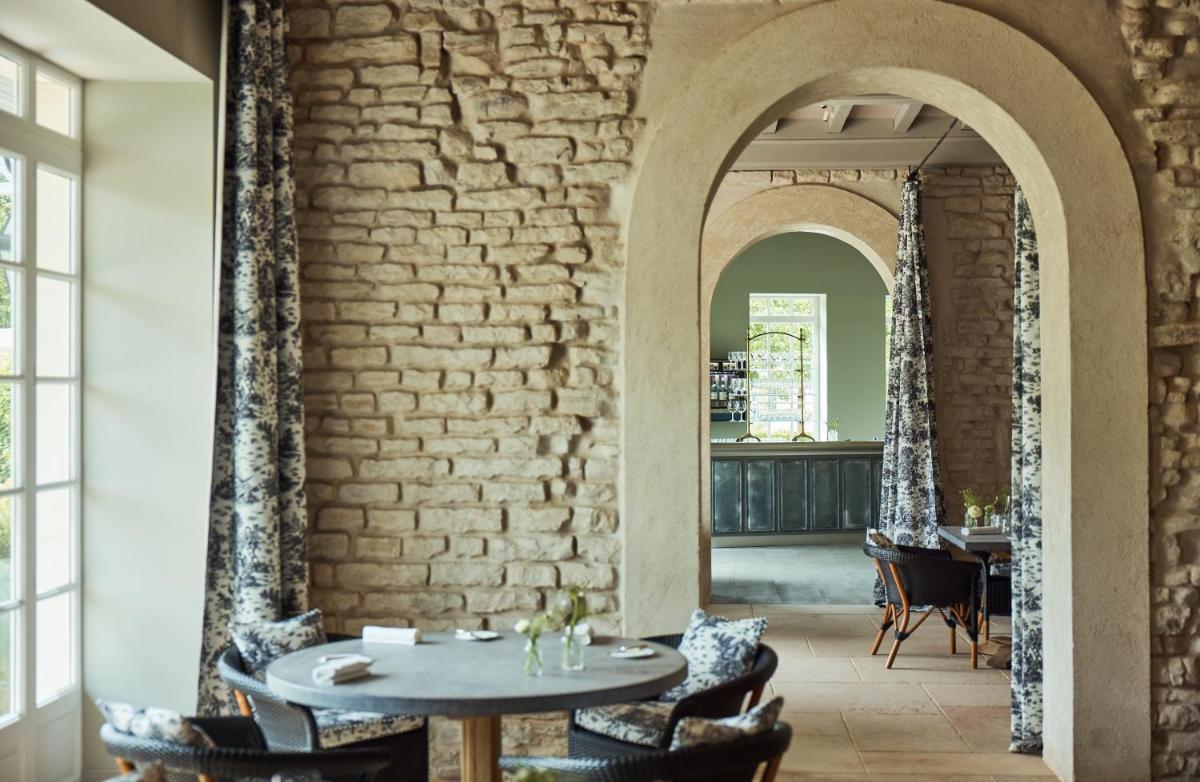 une pièce avec une table et des chaises et un mur de briques dans l'établissement COMO Le Montrachet, à Puligny-Montrachet 37 autres photos
