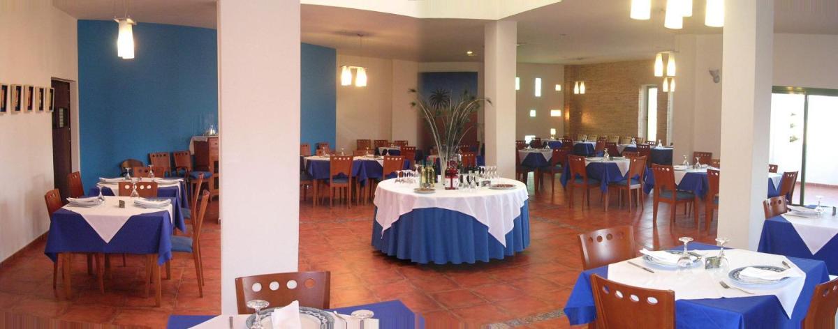 un comedor con mesas y sillas de color azul y blanco en Hotel de Naturaleza Rodalquilar & Spa Cabo de Gata, en Rodalquilar