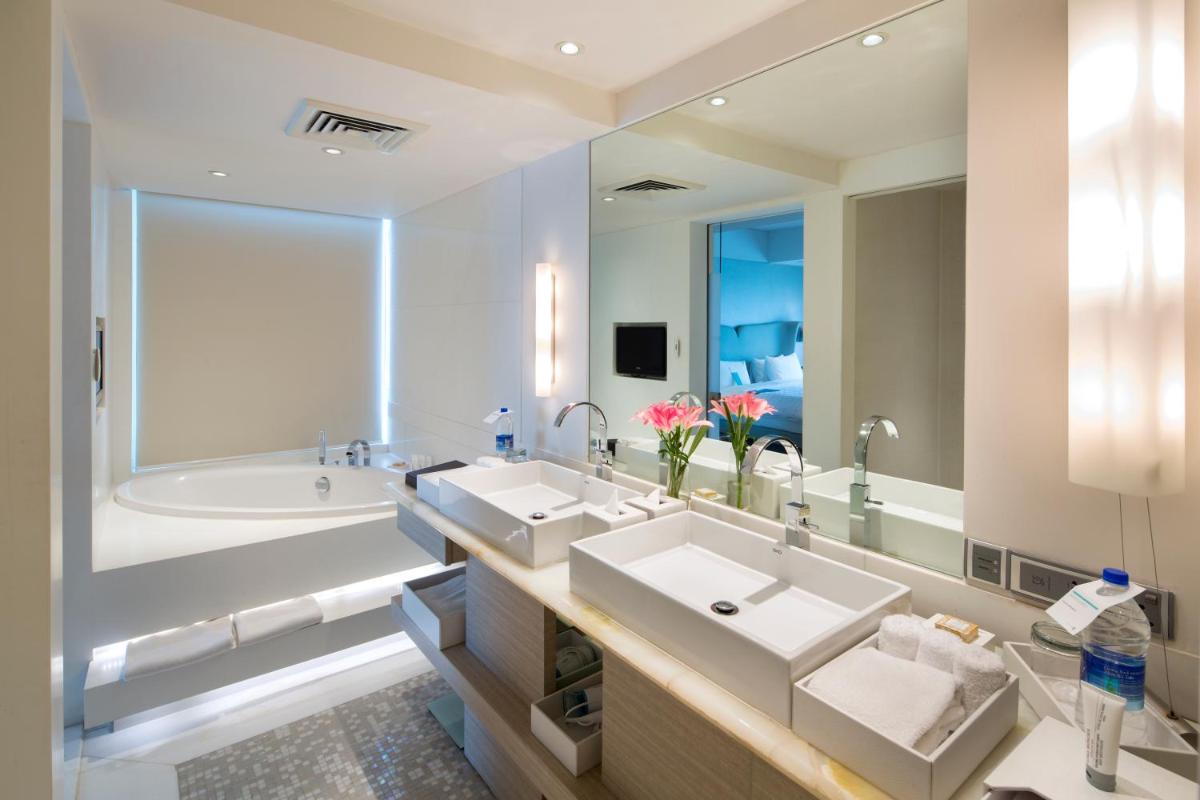 a bathroom with two sinks and a large mirror at Le Meridien Gurgaon, Delhi NCR in Gurgaon a bathroom with two sinks and a large mirror at Le Meridien Gurgaon, Delhi NCR in Gurgaon