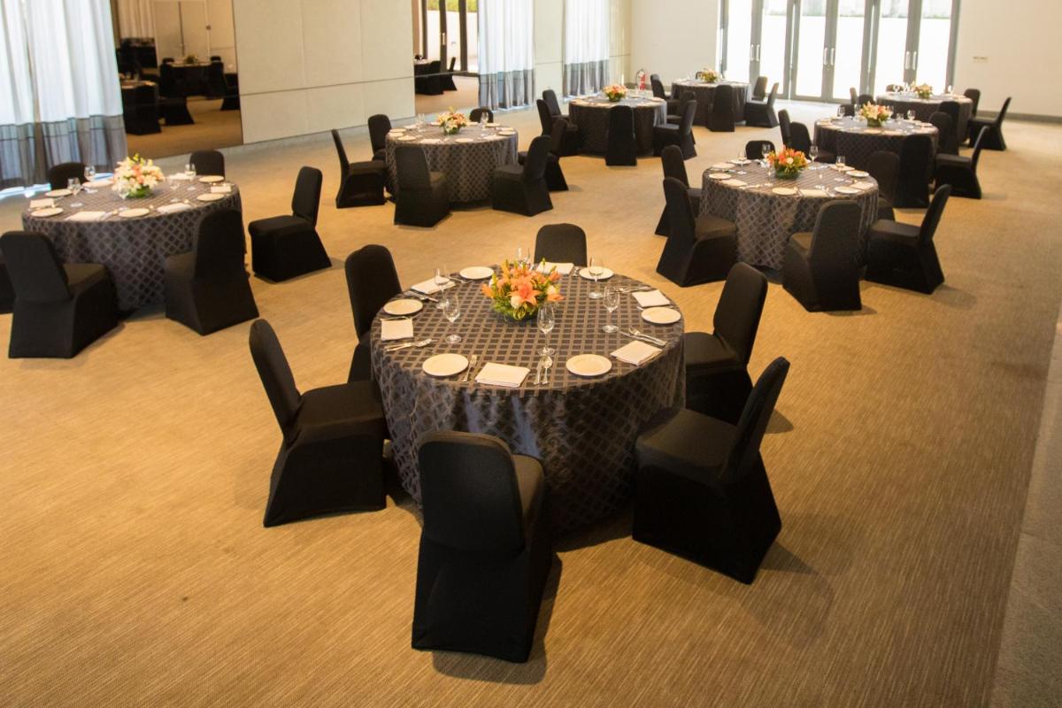 a group of tables and chairs in a room at BLVD Club - Near BENGALURU AIRPORT in Bengaluru