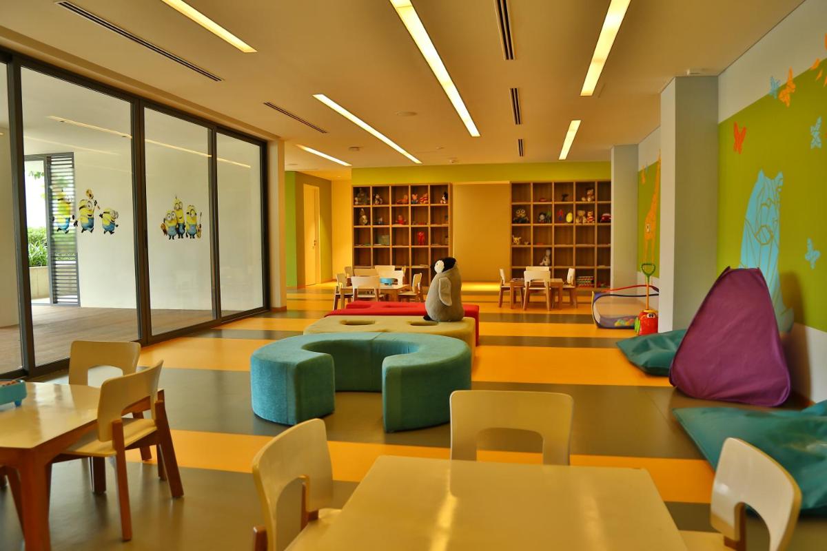 a classroom with tables and chairs and a library at BLVD Club - Near BENGALURU AIRPORT in Bengaluru