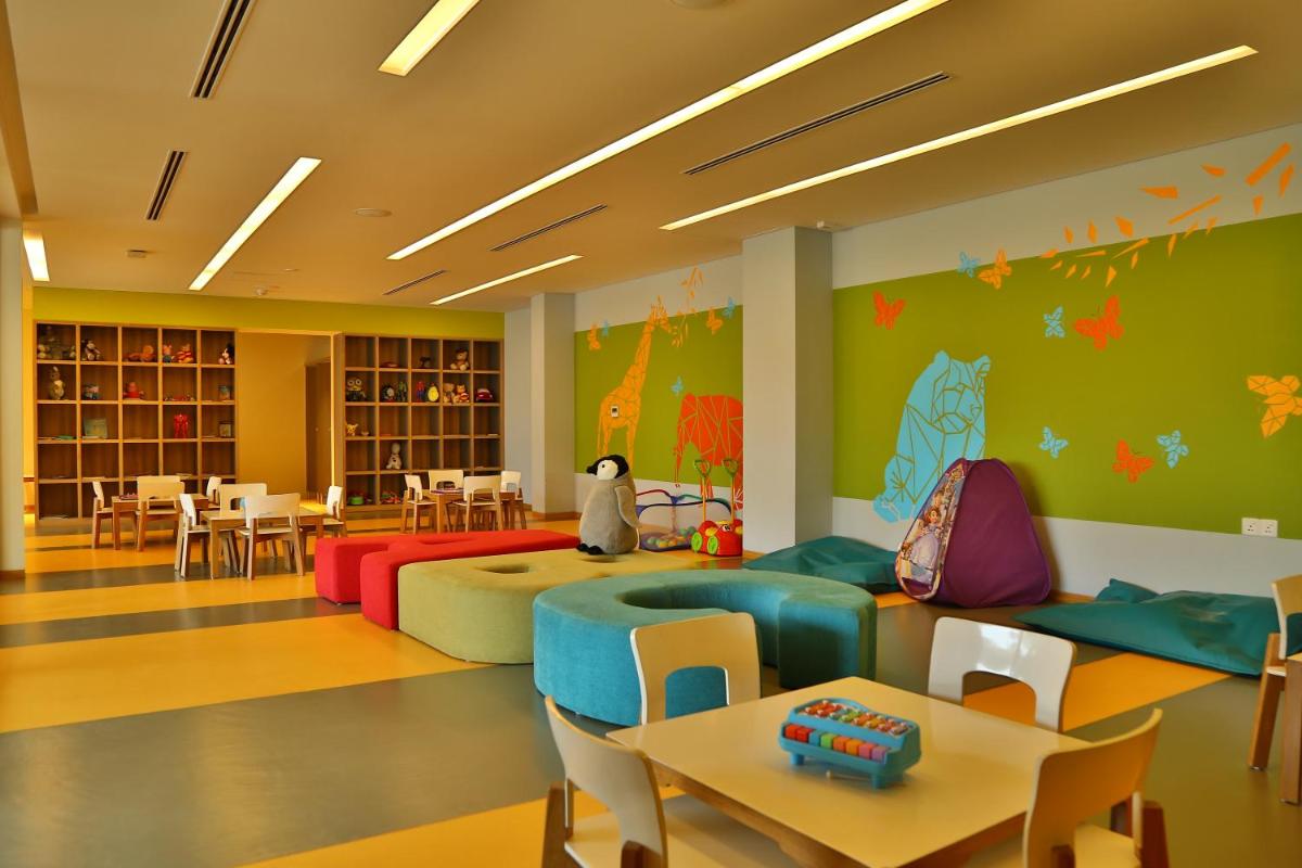 a childrens waiting room with colorful furniture and tables at BLVD Club - Near BENGALURU AIRPORT in Bengaluru