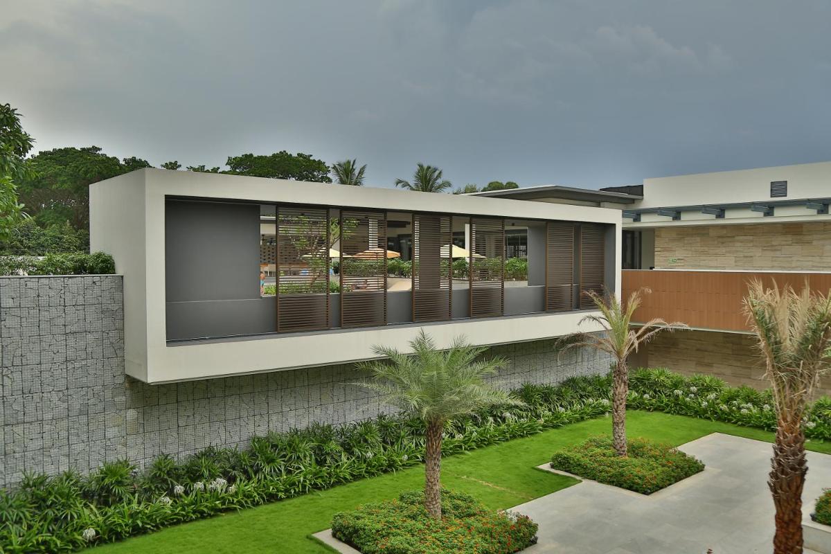 an external view of a house with palm trees at BLVD Club - Near BENGALURU AIRPORT in Bengaluru