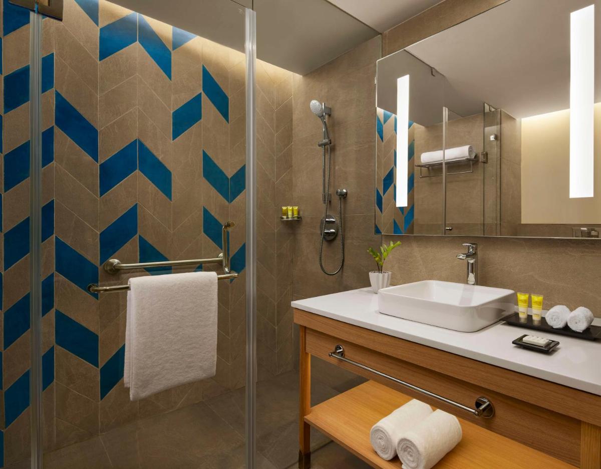 a bathroom with a sink and a shower at Hyatt Place Jaipur Malviya Nagar in Jaipur a bathroom with a sink and a shower at Hyatt Place Jaipur Malviya Nagar in Jaipur