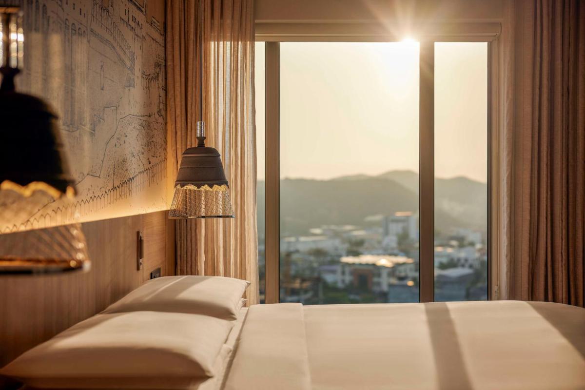 a bedroom with a bed and a window with a view at Hyatt Place Jaipur Malviya Nagar in Jaipur a bedroom with a bed and a window with a view at Hyatt Place Jaipur Malviya Nagar in Jaipur