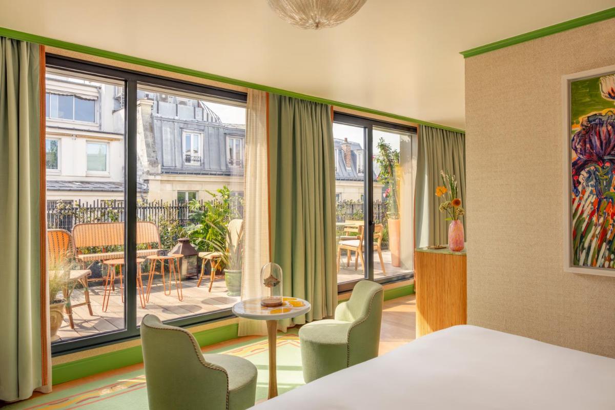 - une chambre avec un lit, des chaises et un balcon dans l'établissement La Fantaisie, à Paris