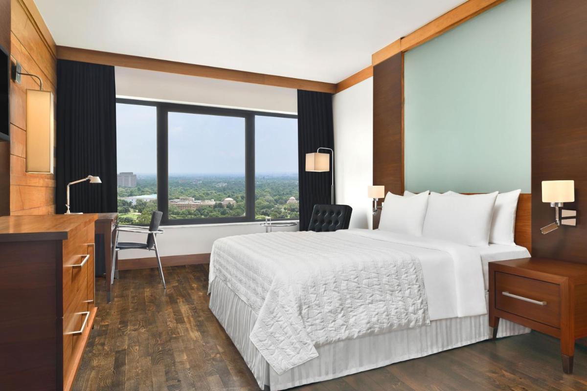 a hotel room with a bed and a desk at Le Meridien New Delhi in New Delhi a hotel room with a bed and a desk at Le Meridien New Delhi in New Delhi
