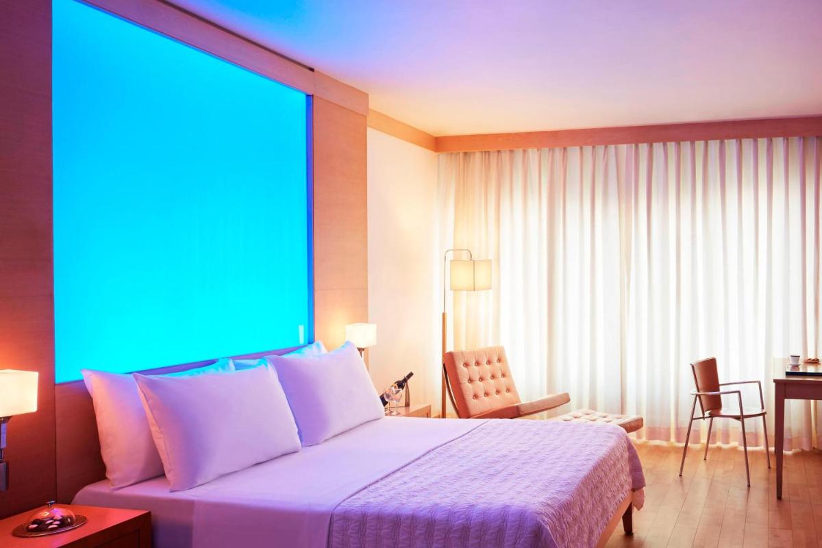 a hotel room with a bed with a blue light at Le Meridien New Delhi in New Delhi a hotel room with a bed with a blue light at Le Meridien New Delhi in New Delhi