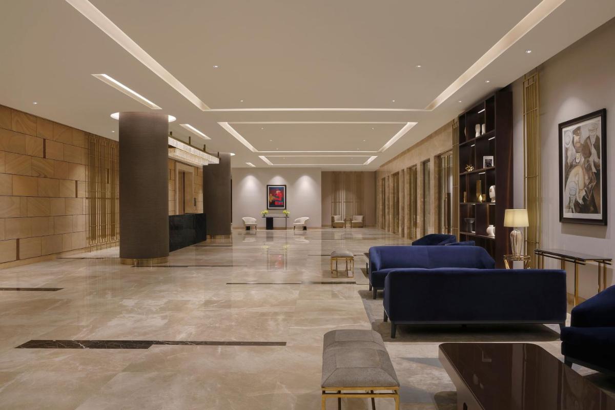 a lobby with couches and chairs in a building at The Westin Pune Koregaon Park in Pune