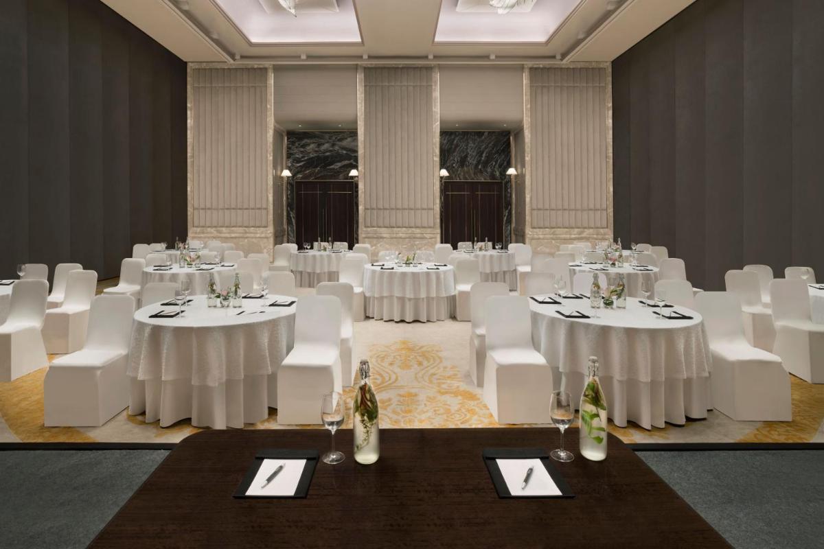 a room with white tables and white chairs in a room at The Westin Pune Koregaon Park in Pune