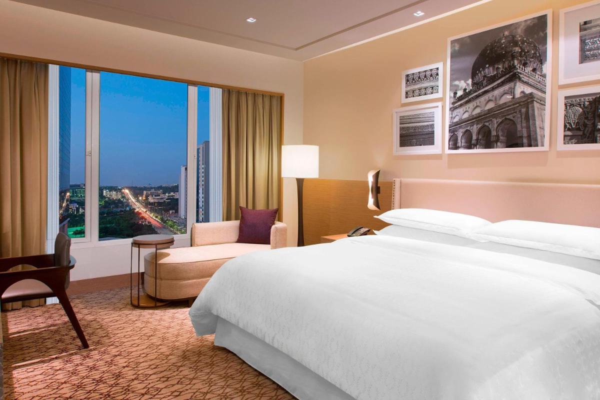 a hotel room with a large bed and a window at Sheraton Hyderabad Hotel in Hyderabad