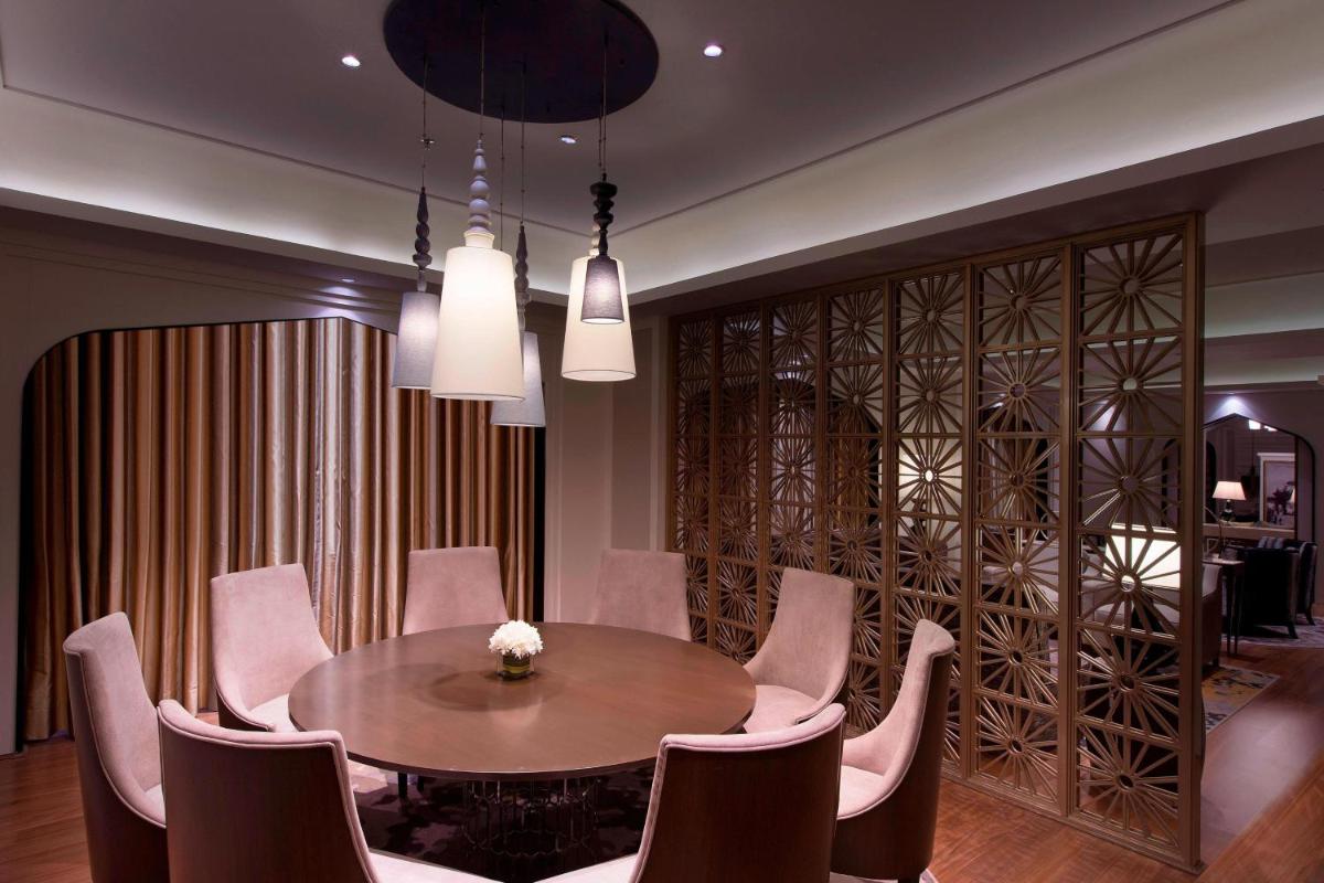 a dining room with a table and chairs at Sheraton Hyderabad Hotel in Hyderabad
