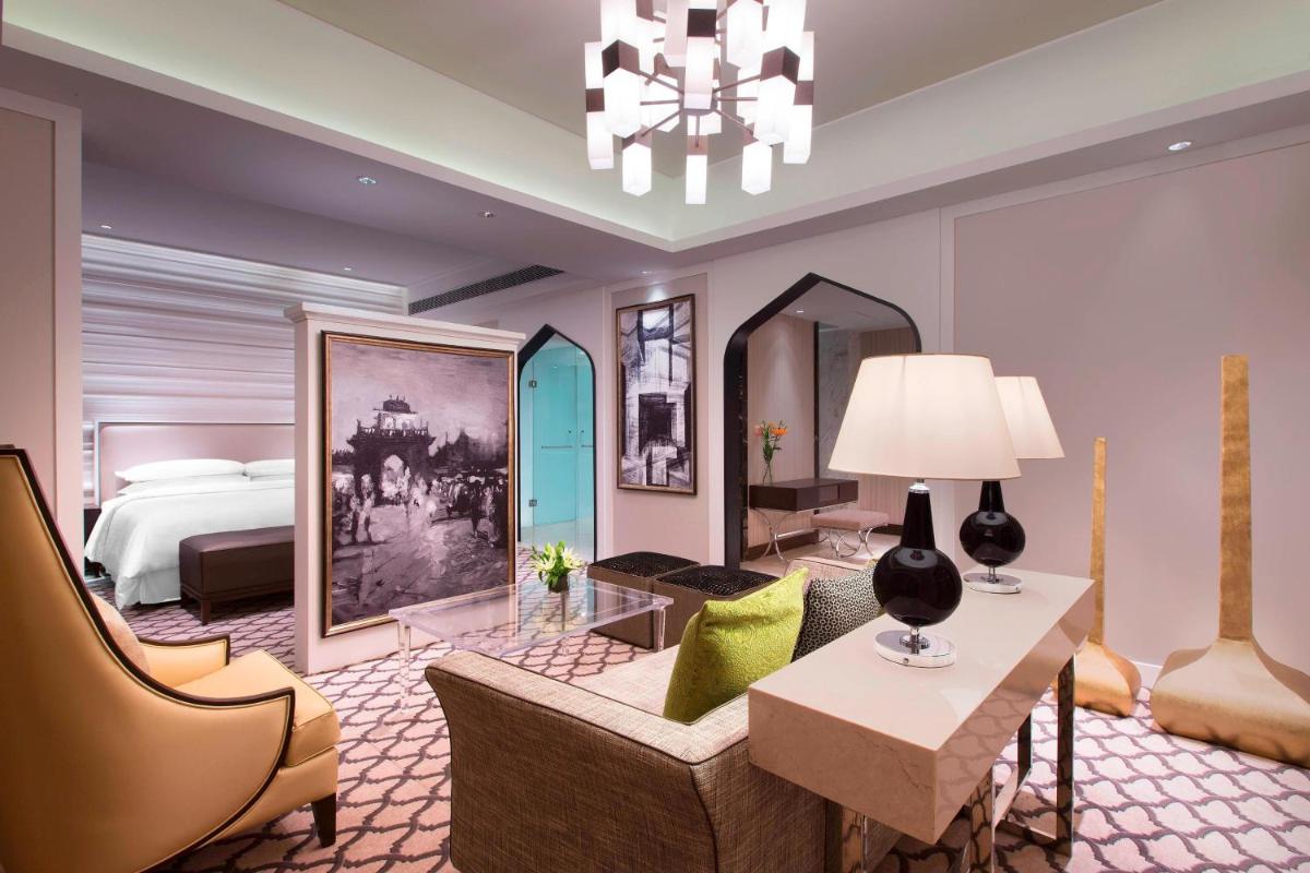 a hotel room with a bed and a living room at Sheraton Hyderabad Hotel in Hyderabad