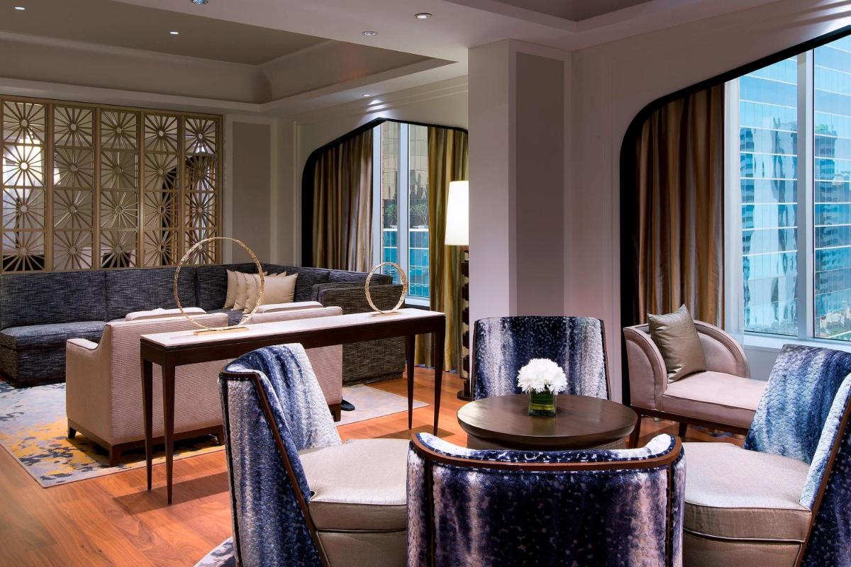 a living room with a table and chairs at Sheraton Hyderabad Hotel in Hyderabad