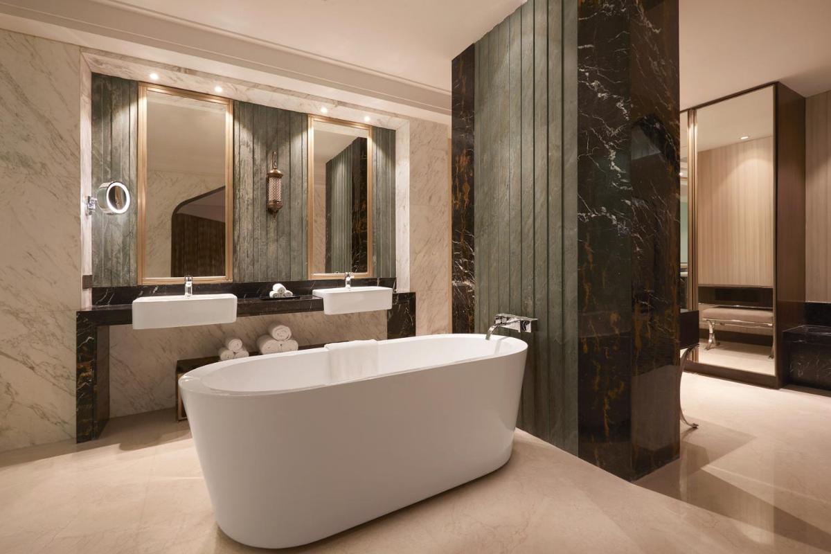 a bathroom with a white tub and two sinks at Sheraton Hyderabad Hotel in Hyderabad