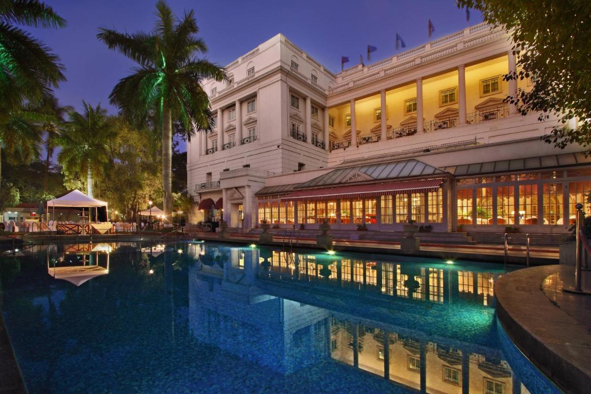 a hotel with a swimming pool in front of a building at ITC Windsor, a Luxury Collection Hotel, Bengaluru in Bengaluru a hotel with a swimming pool in front of a building at ITC Windsor, a Luxury Collection Hotel, Bengaluru in Bengaluru