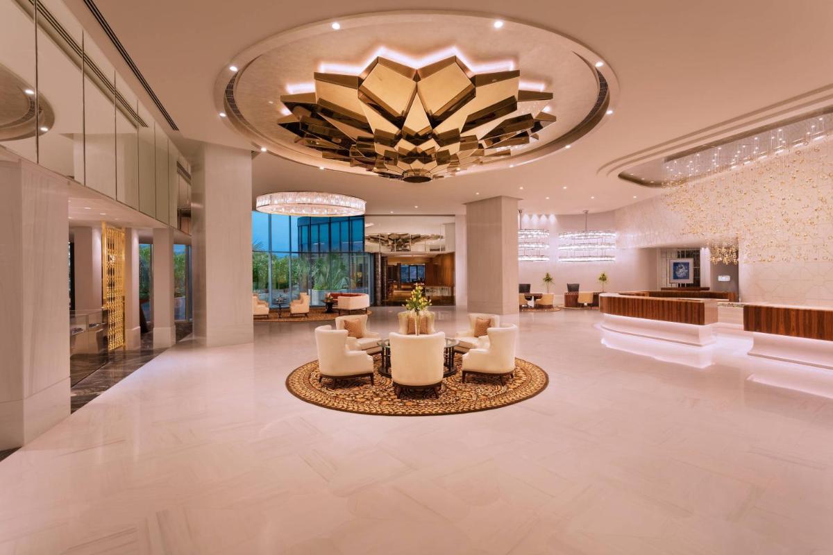 a lobby of a hotel with chairs and a chandelier at ITC Kohenur, a Luxury Collection Hotel, Hyderabad in Hyderabad