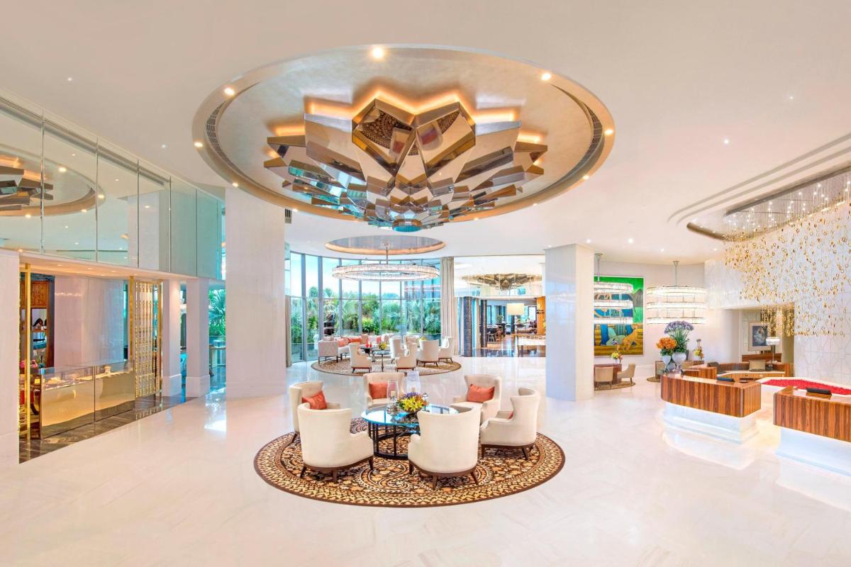 a lobby with white chairs and a large chandelier at ITC Kohenur, a Luxury Collection Hotel, Hyderabad in Hyderabad