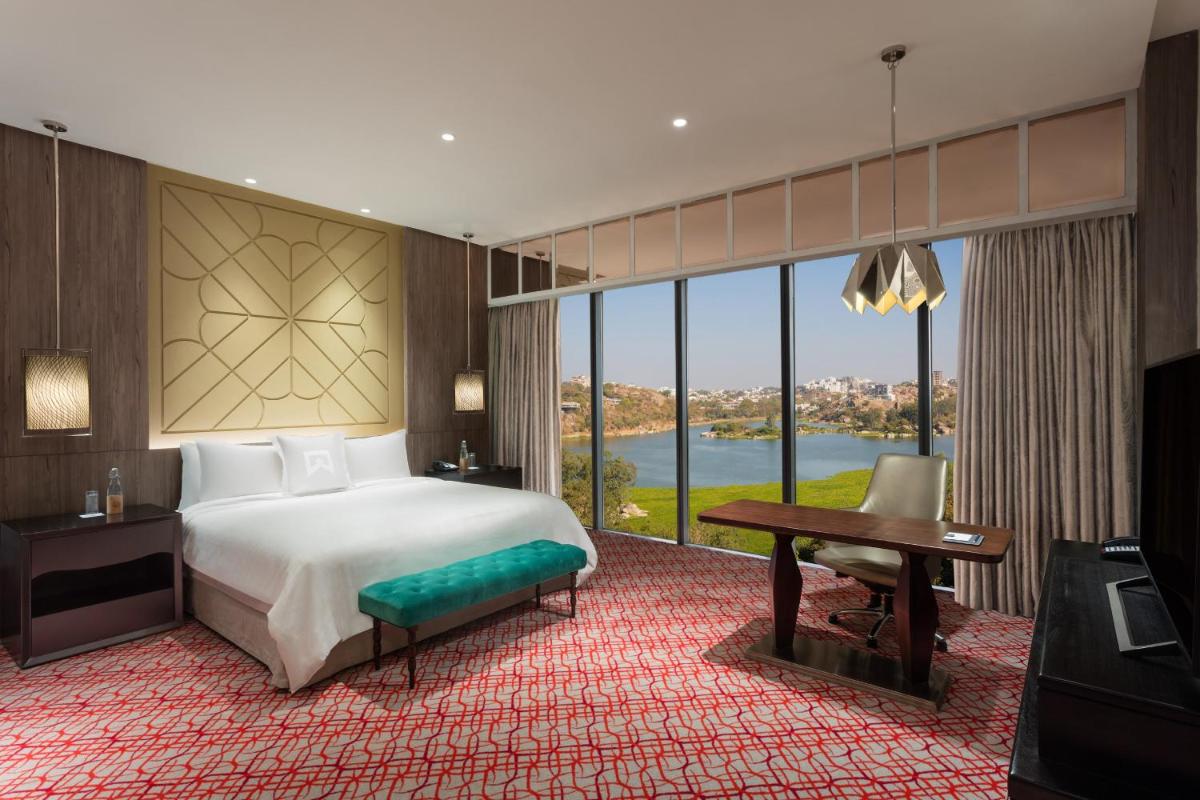 a hotel room with a bed and a desk and a window at ITC Kohenur, a Luxury Collection Hotel, Hyderabad in Hyderabad