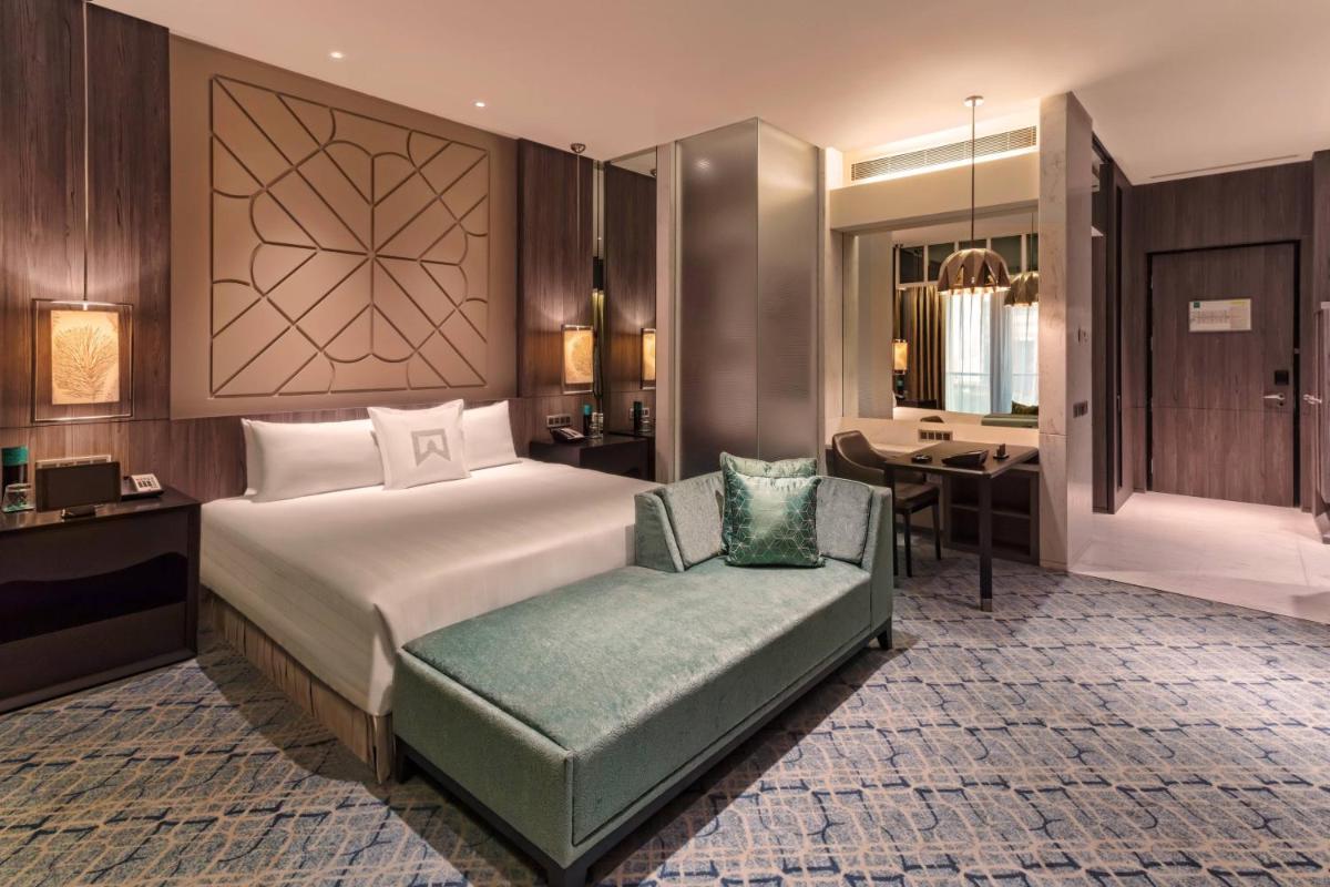 a hotel room with a bed and a chair at ITC Kohenur, a Luxury Collection Hotel, Hyderabad in Hyderabad