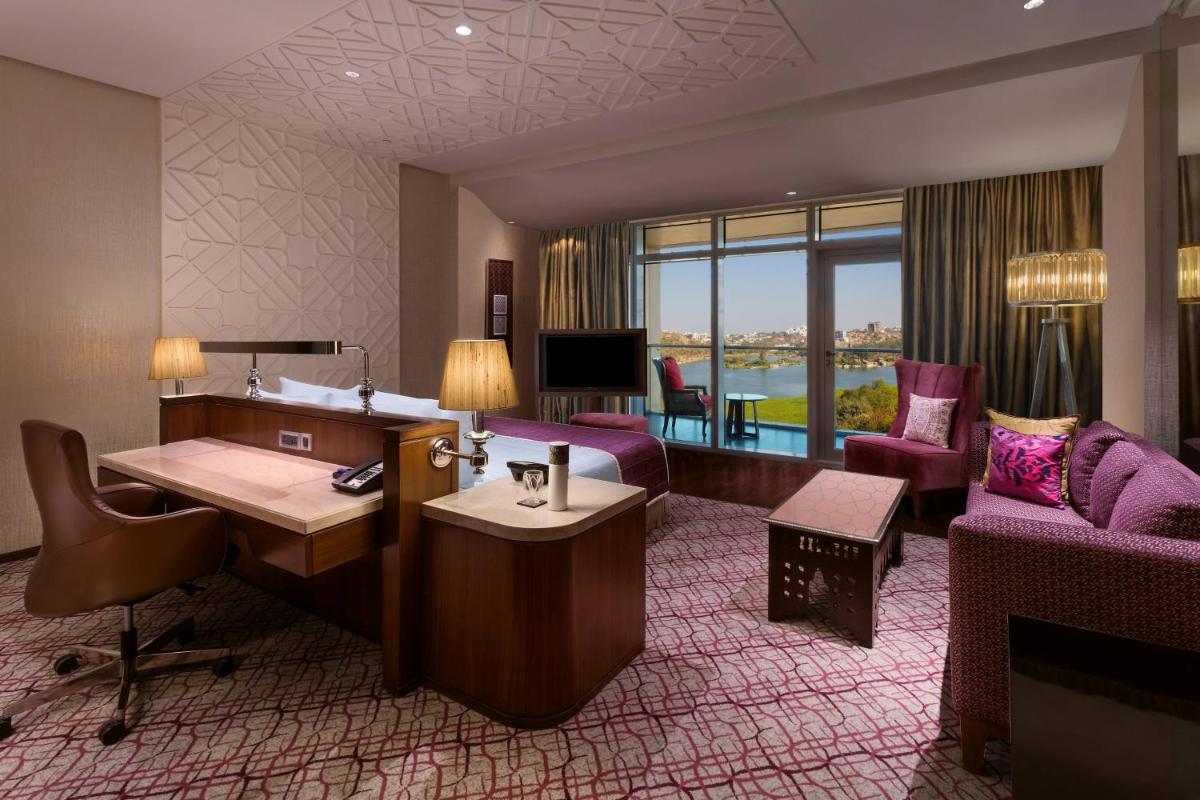 a hotel room with a bed and a desk and a couch at ITC Kohenur, a Luxury Collection Hotel, Hyderabad in Hyderabad