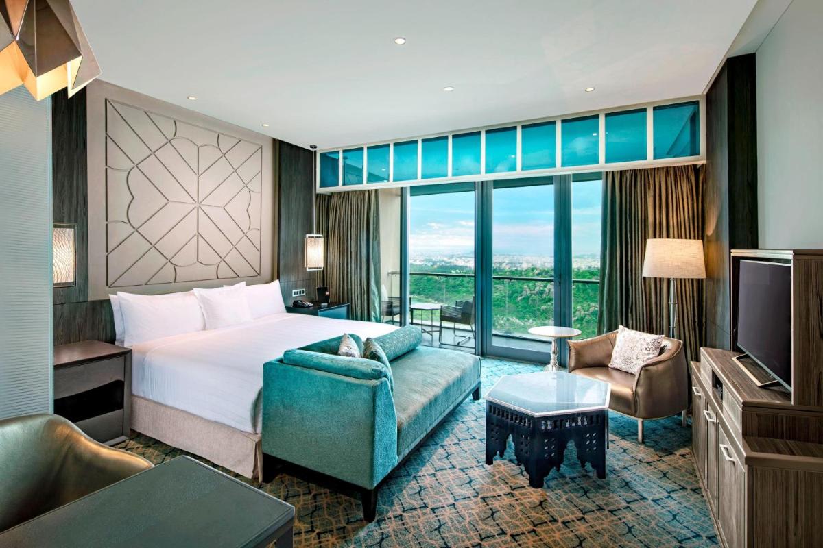 a hotel room with a bed and a couch at ITC Kohenur, a Luxury Collection Hotel, Hyderabad in Hyderabad