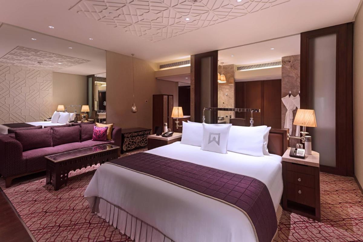 a hotel room with a large bed and a couch at ITC Kohenur, a Luxury Collection Hotel, Hyderabad in Hyderabad