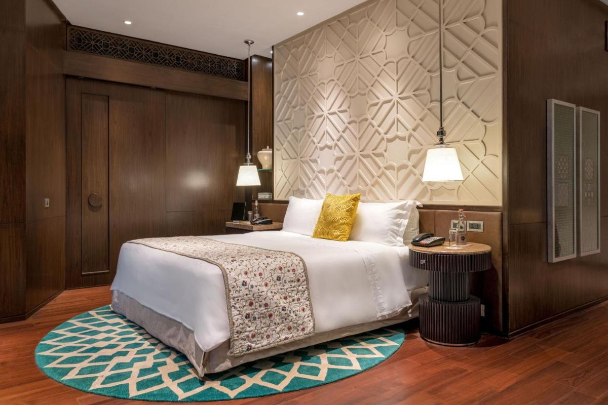 a bedroom with a large white bed and a rug at ITC Kohenur, a Luxury Collection Hotel, Hyderabad in Hyderabad