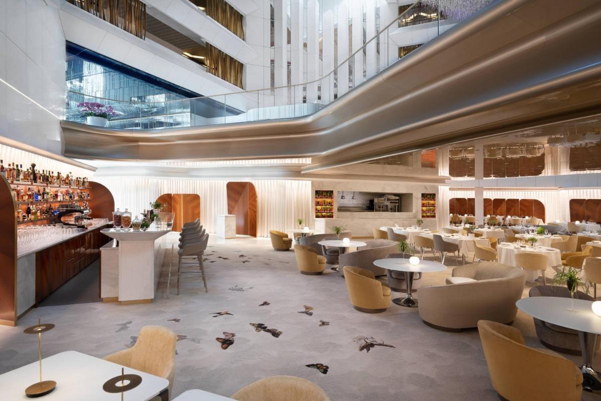 un restaurant avec des tables et des chaises et un bar dans l'établissement JW Marriott Cannes, à Cannes