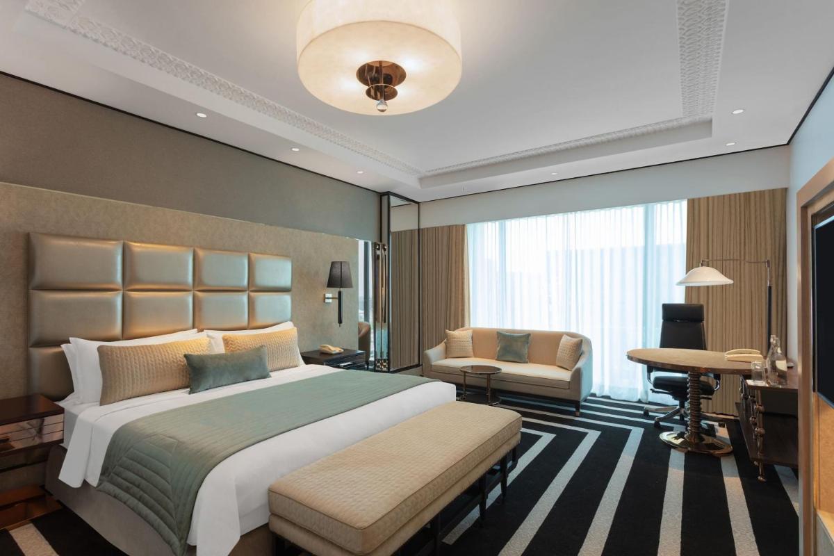 a bedroom with a large bed and a desk at ITC Narmada, a Luxury Collection Hotel, Ahmedabad in Ahmedabad