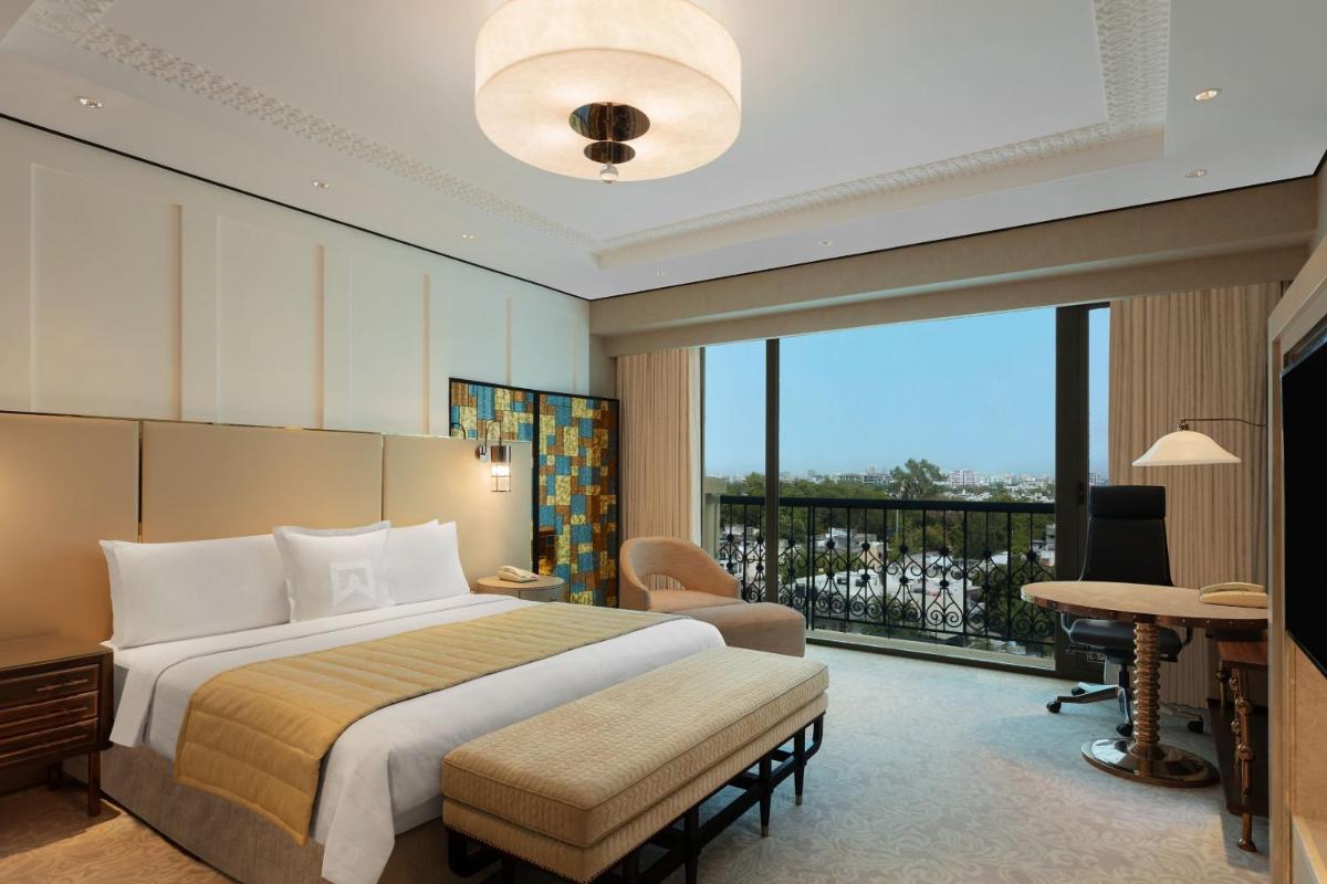 a hotel room with a bed and a balcony at ITC Narmada, a Luxury Collection Hotel, Ahmedabad in Ahmedabad