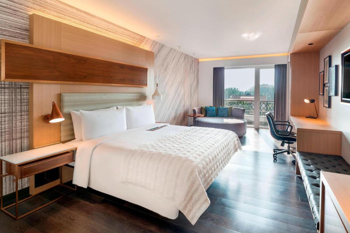 a hotel room with a bed and a desk at Le Meridien Goa, Calangute in Calangute a hotel room with a bed and a desk at Le Meridien Goa, Calangute in Calangute