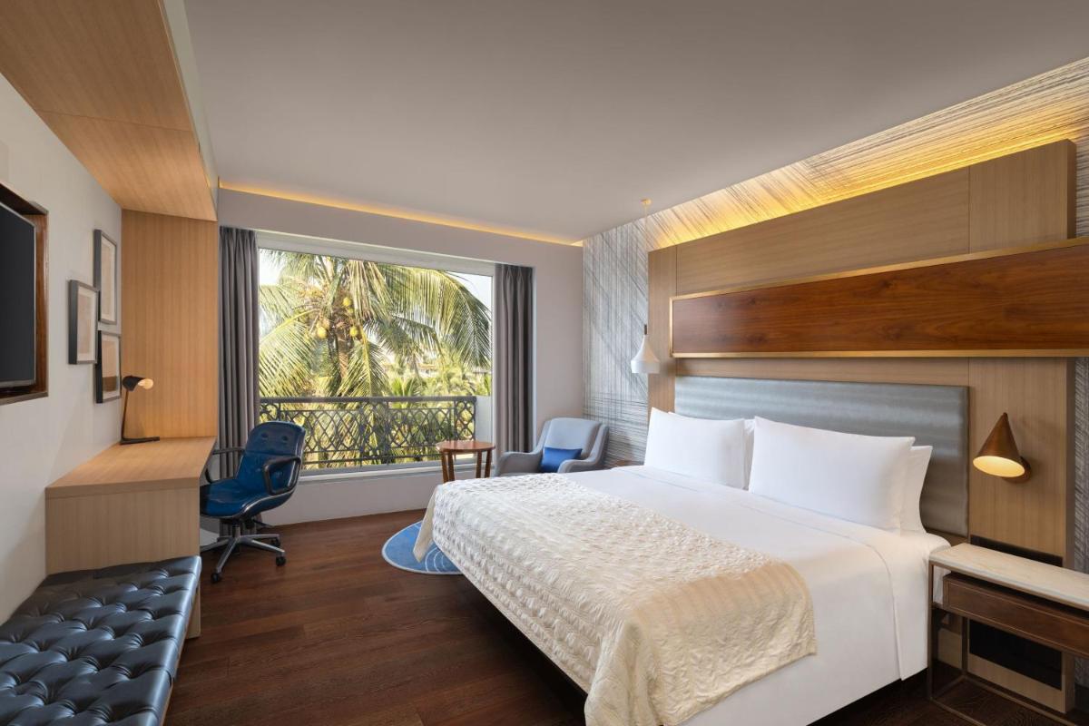 a hotel room with a bed and a window at Le Meridien Goa, Calangute in Calangute a hotel room with a bed and a window at Le Meridien Goa, Calangute in Calangute