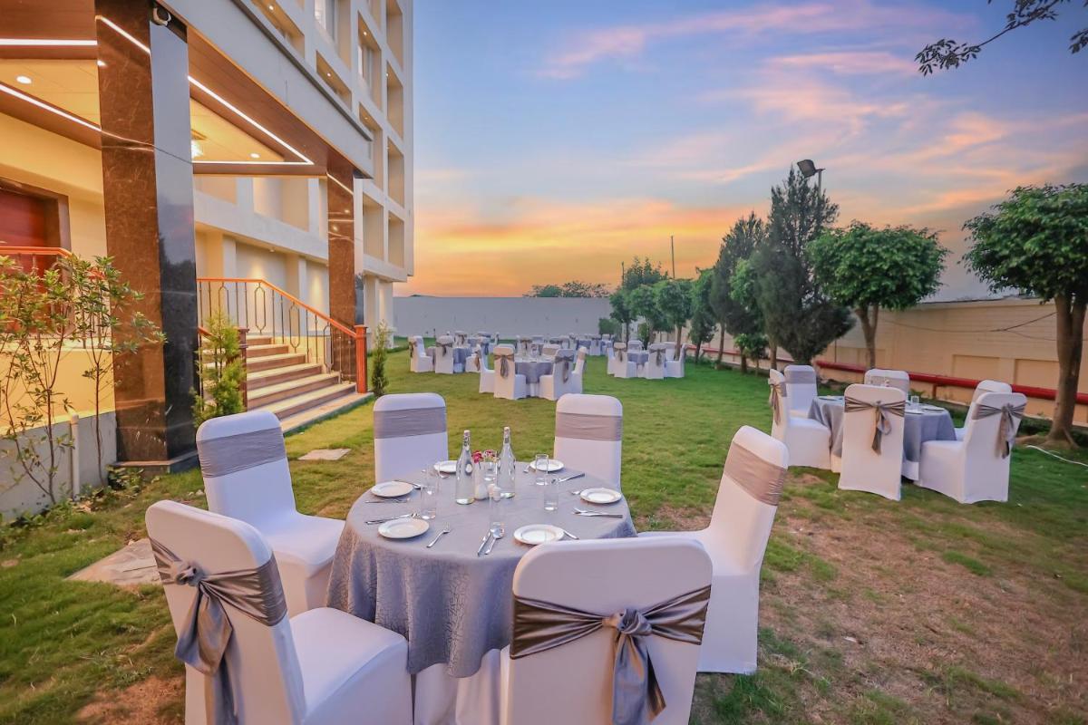a group of white chairs and tables in a yard at Regenta Dehradun by Royal Orchid Hotels Limited in Dehradun