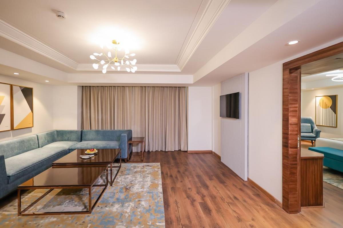a living room with a couch and a table at Regenta Dehradun by Royal Orchid Hotels Limited in Dehradun