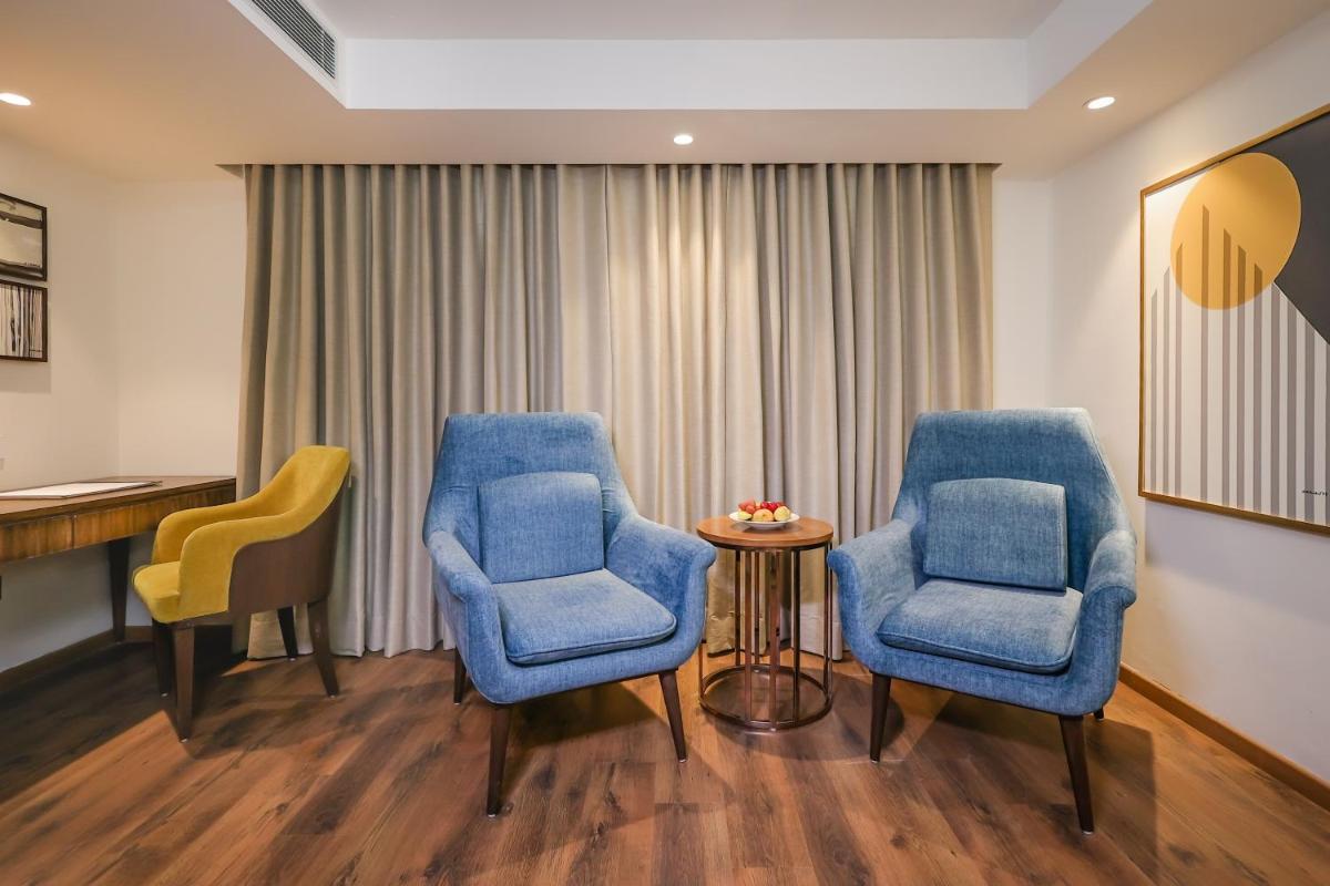 a waiting room with two blue chairs and a table at Regenta Dehradun by Royal Orchid Hotels Limited in Dehradun