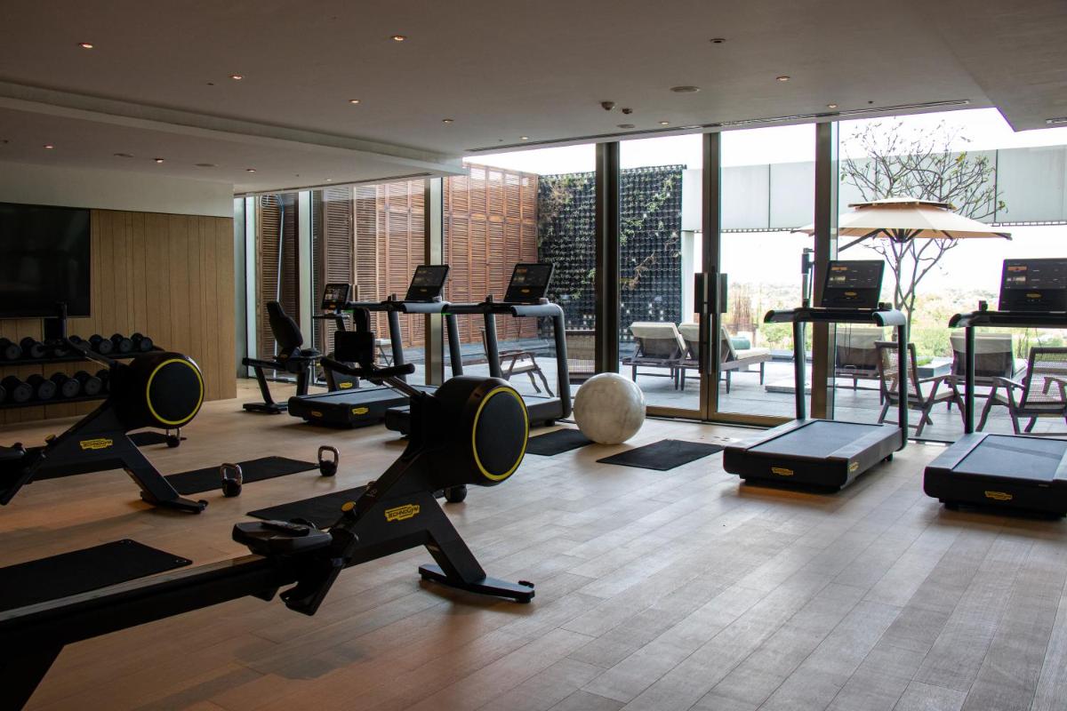 a gym with treadmills and exercise equipment in a building at Grand Hyatt Gurgaon in Gurgaon
